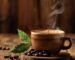 A steaming cup of single origin coffee on a wooden table with coffee beans and a plant in the background