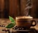 A steaming cup of single origin coffee on a wooden table with coffee beans and a plant in the background